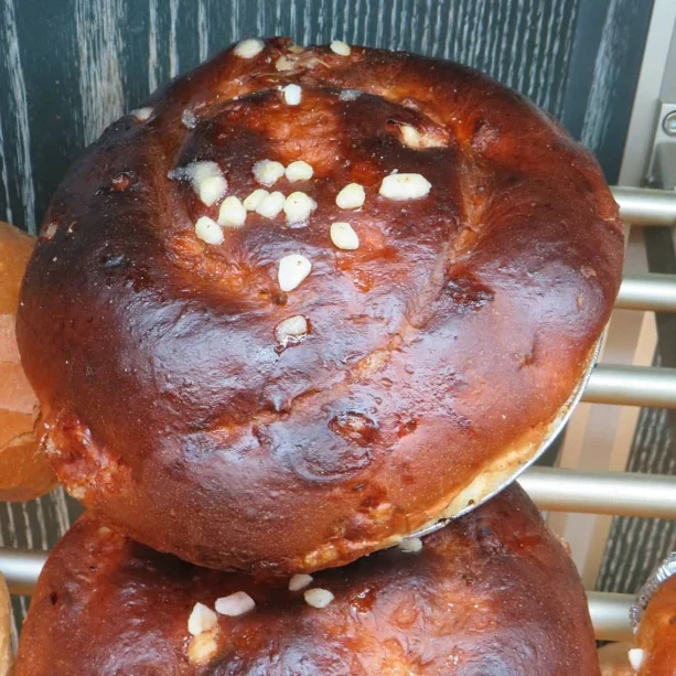Twee verse, glanzende broodjes met stukjes suiker bovenop